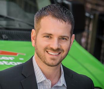 A headshot of CEO Doug Glassman in front of a SERVPRO work van