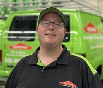 Male with hat standing in front of SERVPRO van 